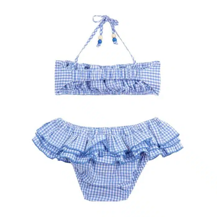 Maillot de bain deux pièces à volants en coton carreaux vichy bleu et blanc. Haut du maillot forme bandeau à volant avec élastique dans le dos et bas du maillot coupe taille basse à volants. Maillot de bain deux pièces pour filles, fillettes et ados de la marque de mode pour enfant LA FAUTE A VOLTAIRE